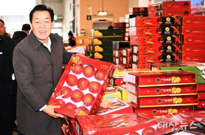 이재준 수원시장이 지난 설 명절을 앞두고 수원시 농수산물도매시장을 방문해 과일 상자를 들어보고 있다.