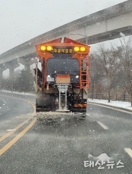제설차량이 도로에 제설제를 살포하고 있다