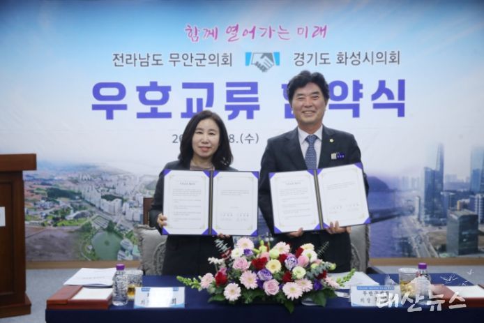 화성시의회(김경희 의장)와 무안군의회(김경현)가 우호교류 협약서 든 모습