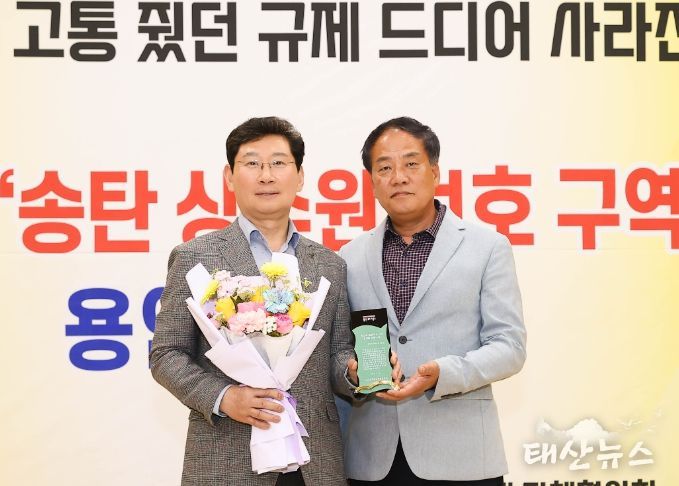 이상일 용인특례시장이 24일 처인구 이통장연합회가 남사읍 주민자치센터에서 개최한 송탄 상수원 보호구역 해제 협약 기념 연합회의에서 감사패를 맏고 있다.