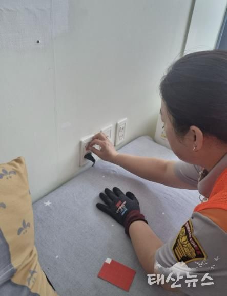 콘센트용 자동소화패치 부착하고 있는 모습