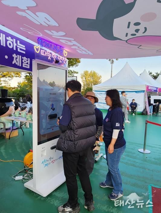 지난 25일 '안산페스타 2025'에 참여한 한 시민이 행사장에서 운영중인 나눔 키오스크를 이용, 기부에 참여하고 있다.