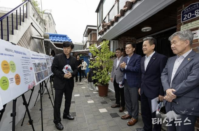 수원시와 한국보훈복지의료공단이 수원지역 독립유공자 후손의 집수리를 지원한 새빛하우스 앞에서 관계자들이 사업 설명을 듣고 있다.