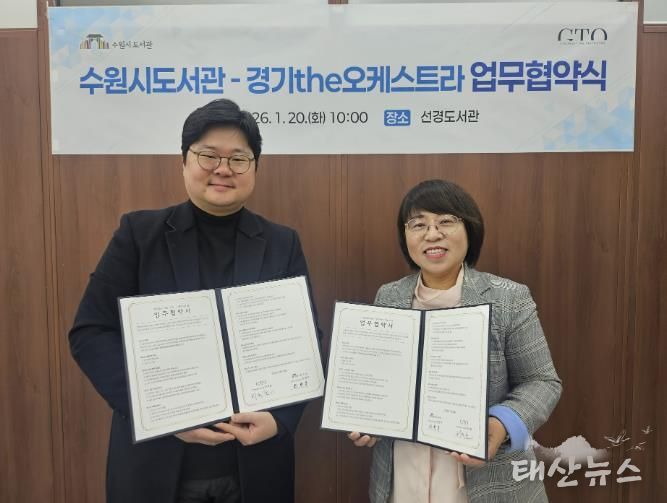 최현주 수원시도서관사업소장(오른쪽)과 허석환 경기더(the)오케스트라 관계자가 협약 후 기념촬영을 하고 있다.