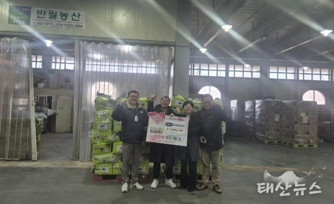 19일 안산농수산물도매시장 관계자와 반월농산 관계자가 푸드뱅크 나눔행사를 진행하고 기념촬영을 하고 있다.