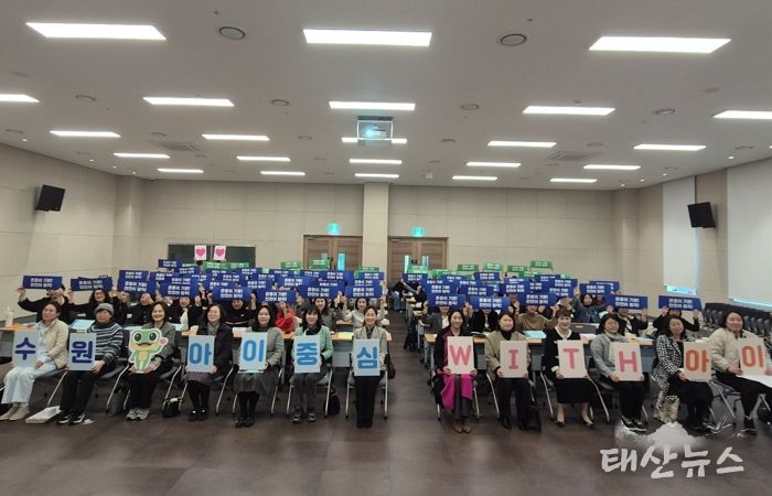 참석자들이 ‘수원, 아이중심 위드(WITH) 아이’ 슬로건 카드를 들고 기념촬영을 하고 있다.