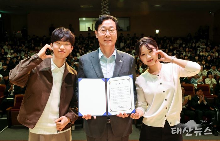 정명근 화성특례시장이 화성시장학관 신규 입사생 대표들과 함께 입사 선서문을 들고 기념촬영을 하고 있다.